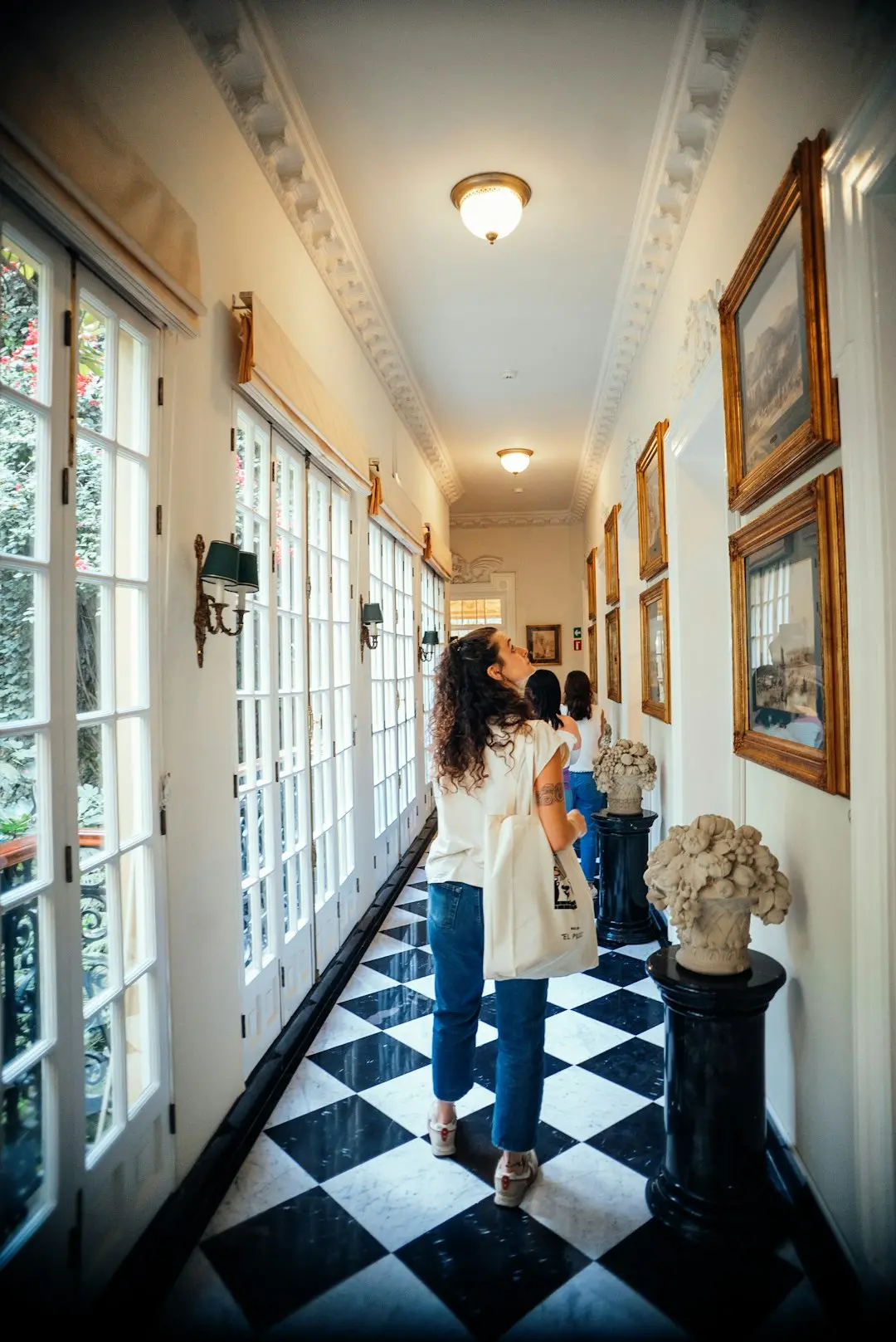a woman is walking down a long hallway